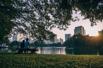 Man and woman viewing city from park bench