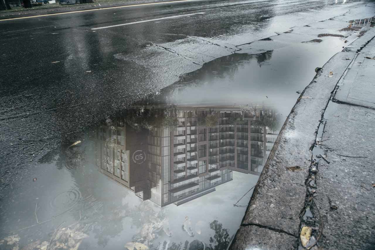Reflection of Stockyards District Condos in a puddle.