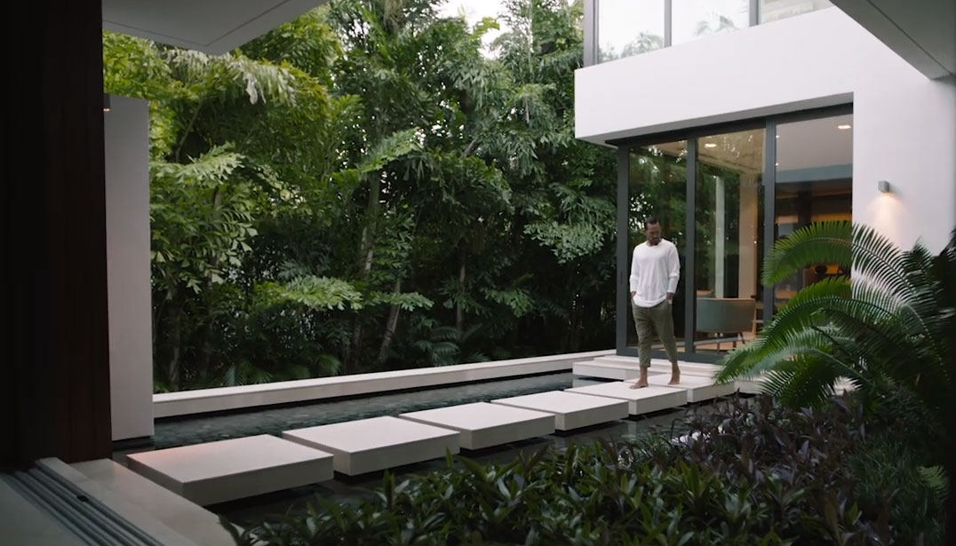 Man walking across modern outdoor path at a private home.