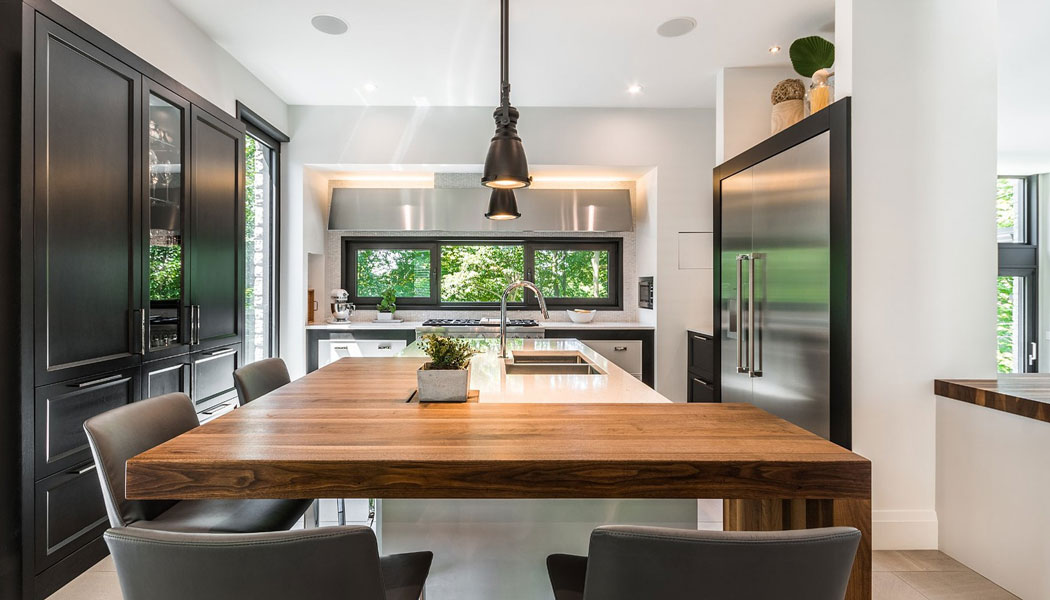 Modern kitchen with walnut countertop and stainless steel appliances.
