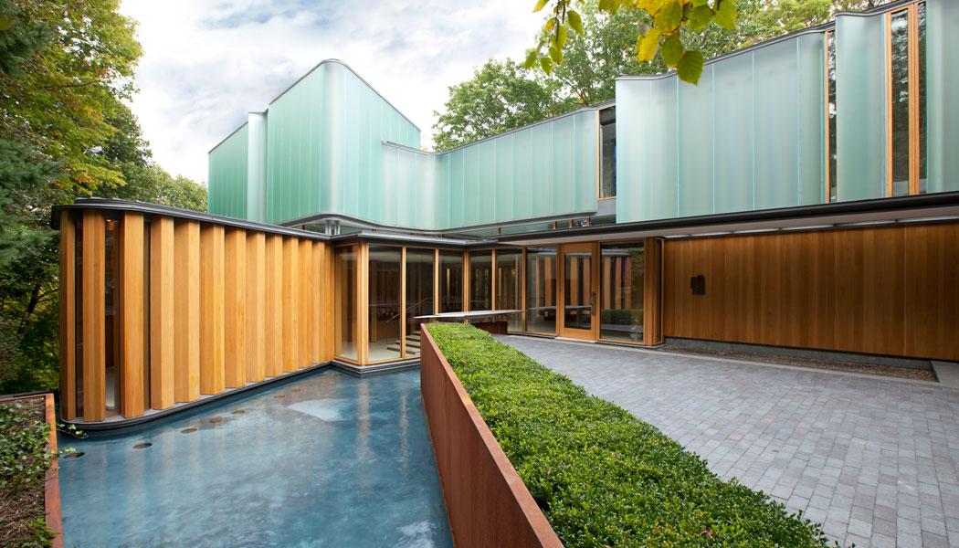 Uniquely modern home with fine architectural wood, glass and water detailing on the exterior.