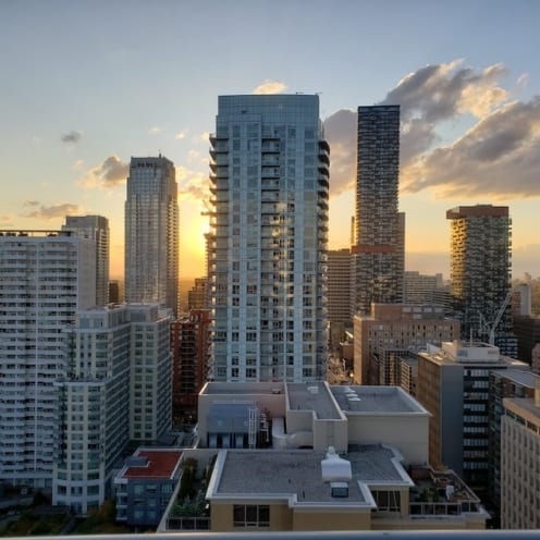 Toronto Condos in skyline with sun setting behind the buildings