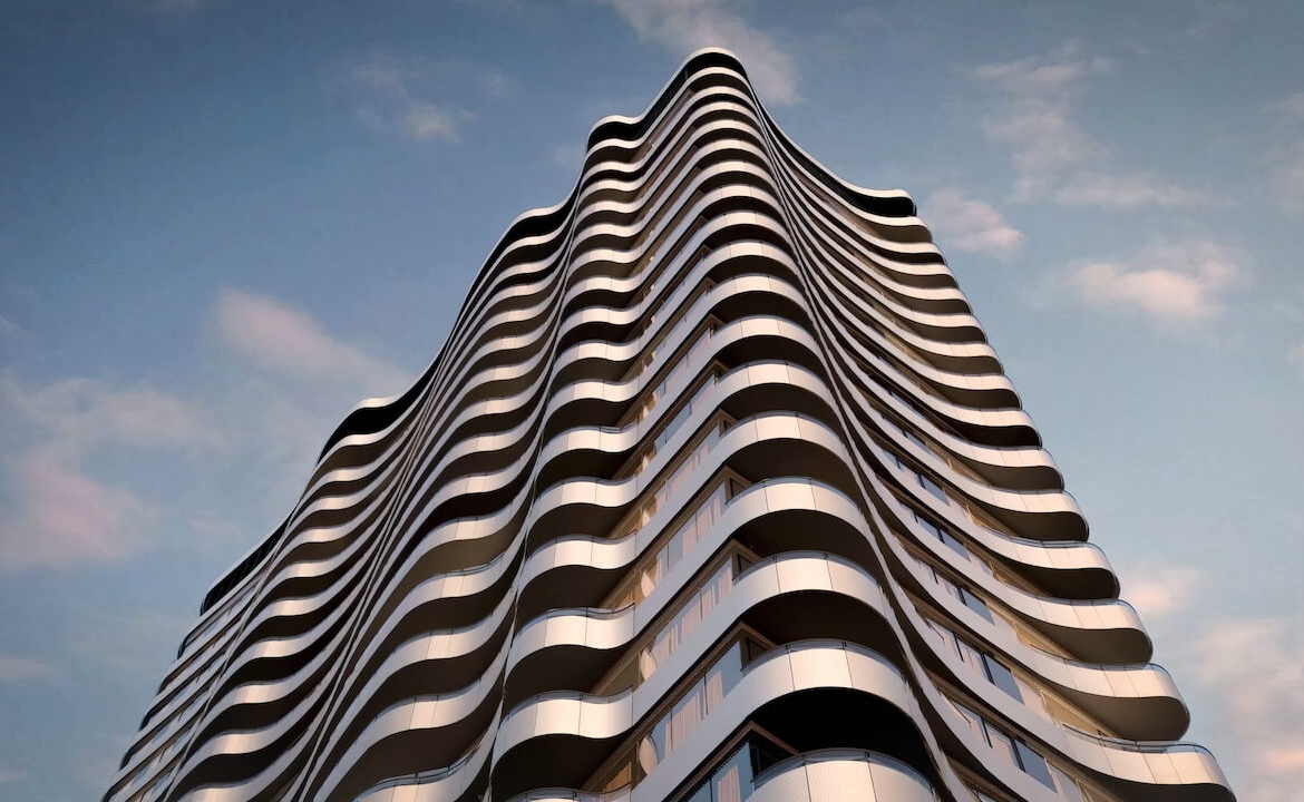 Close-up view of a contemporary building facade with wavy balconies against a clear blue sky.
