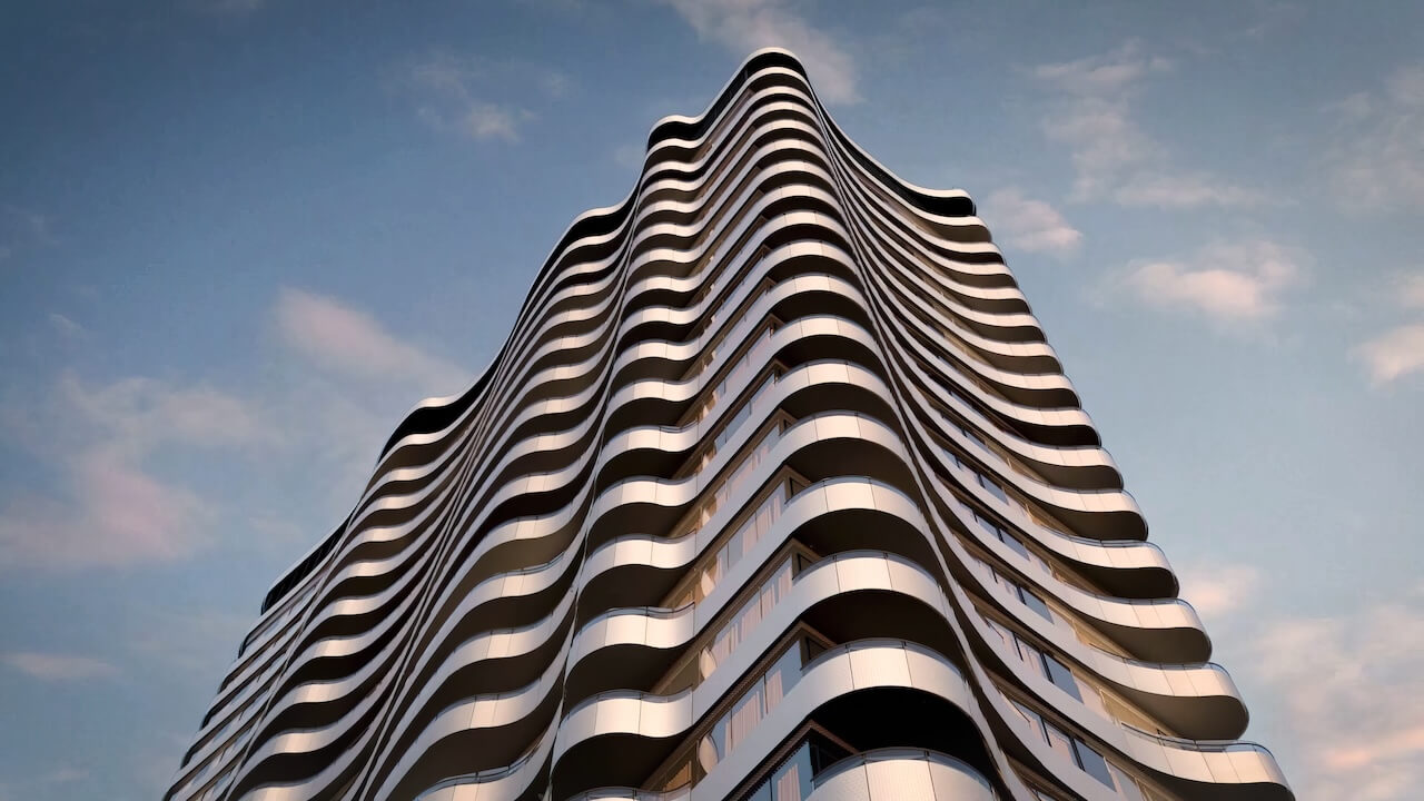 Close-up view of a contemporary building facade with wavy balconies against a clear blue sky.